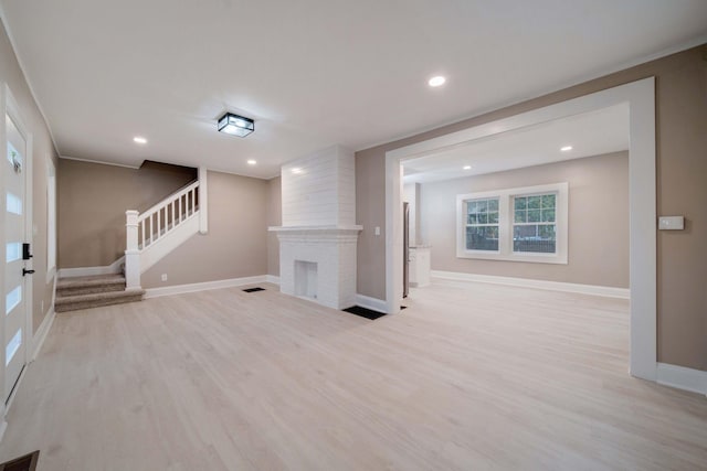 unfurnished living room featuring light wood-type flooring and a fireplace