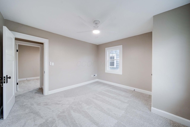 spare room featuring light carpet and ceiling fan