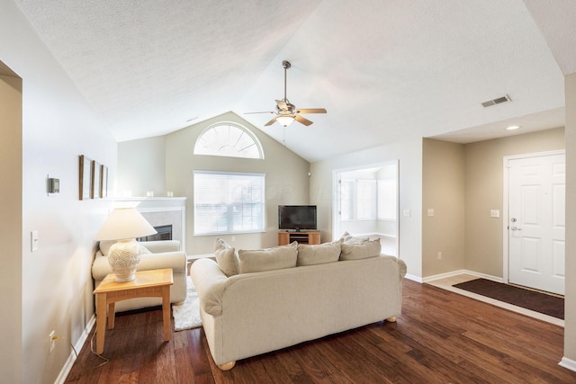 living room with ceiling fan, dark hardwood / wood-style flooring, and lofted ceiling