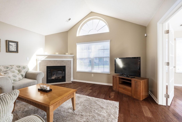 living room featuring dark wood-type flooring, lofted ceiling, and a fireplace