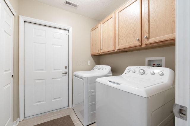 laundry room featuring cabinets and washing machine and clothes dryer