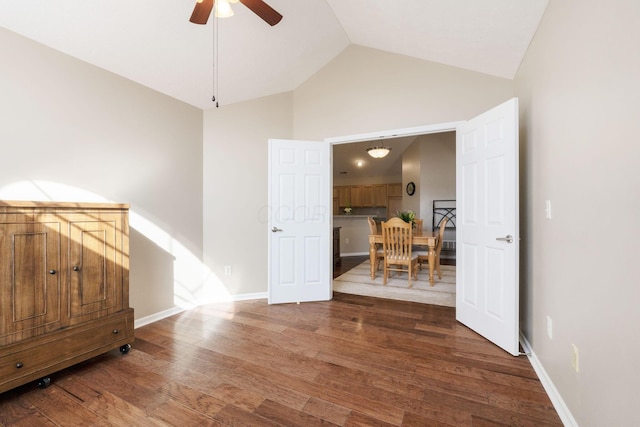 empty room with ceiling fan, dark hardwood / wood-style flooring, and high vaulted ceiling