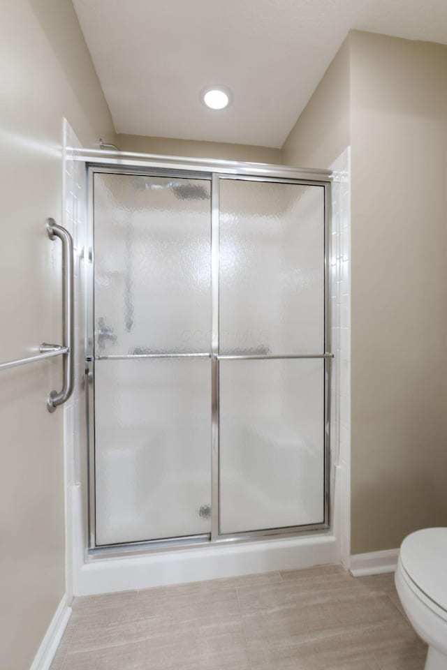 bathroom with toilet and an enclosed shower