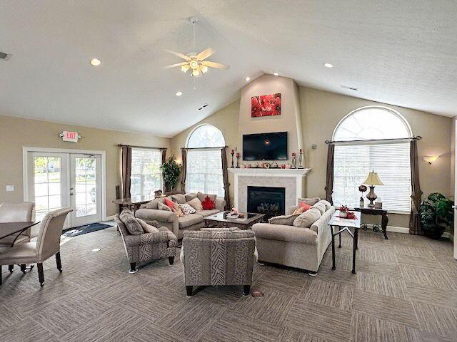 living room featuring ceiling fan, high vaulted ceiling, french doors, and carpet flooring