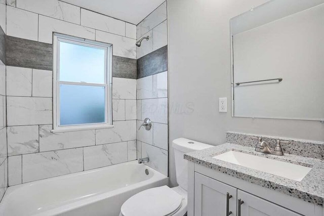 full bathroom with toilet, vanity, and tiled shower / bath