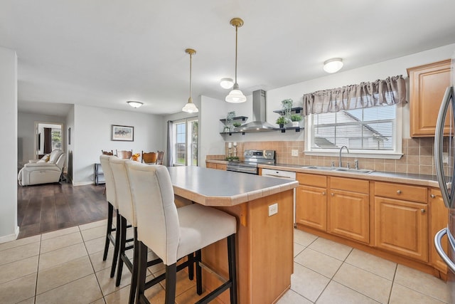 kitchen with a kitchen breakfast bar, wall chimney range hood, electric stove, light hardwood / wood-style flooring, and a kitchen island