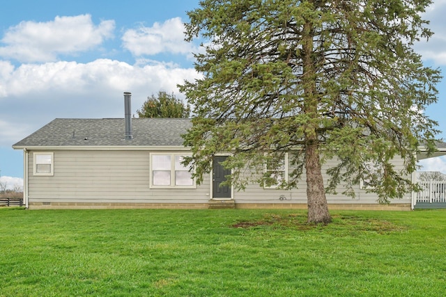 rear view of property featuring a lawn