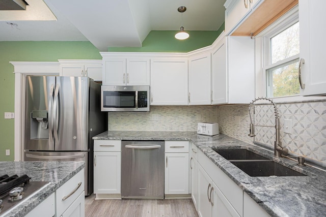 kitchen with tasteful backsplash, white cabinetry, sink, and stainless steel appliances