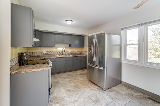 kitchen with stainless steel fridge, electric stove, gray cabinetry, and sink