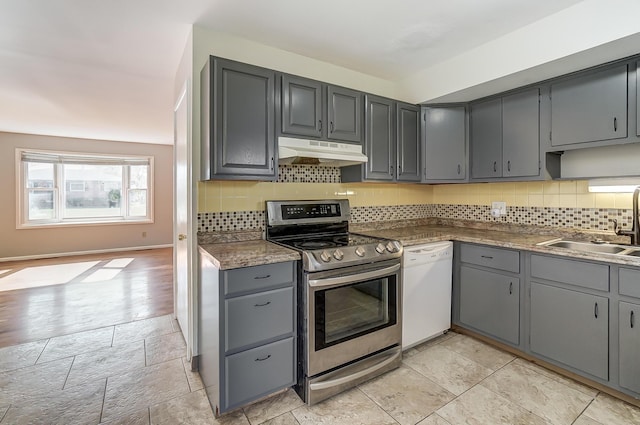 kitchen featuring stainless steel range with electric stovetop, gray cabinetry, backsplash, white dishwasher, and sink