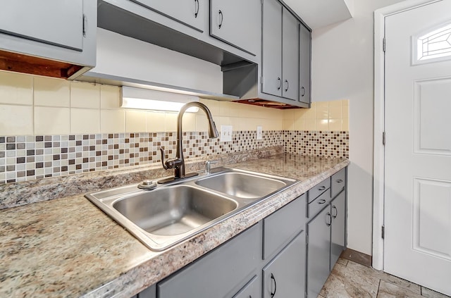 kitchen featuring gray cabinetry, decorative backsplash, and sink