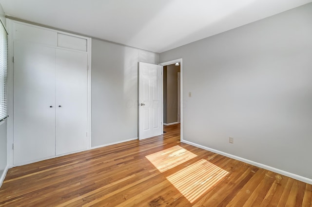 unfurnished bedroom with hardwood / wood-style flooring and a closet