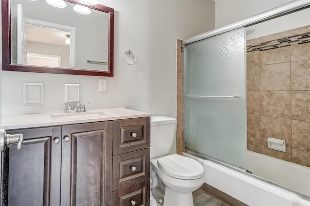 full bathroom with shower / bath combination with glass door, vanity, and toilet