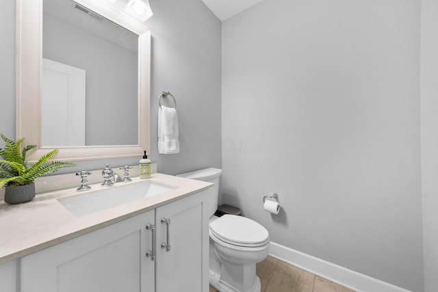 bathroom featuring tile patterned flooring, vanity, and toilet