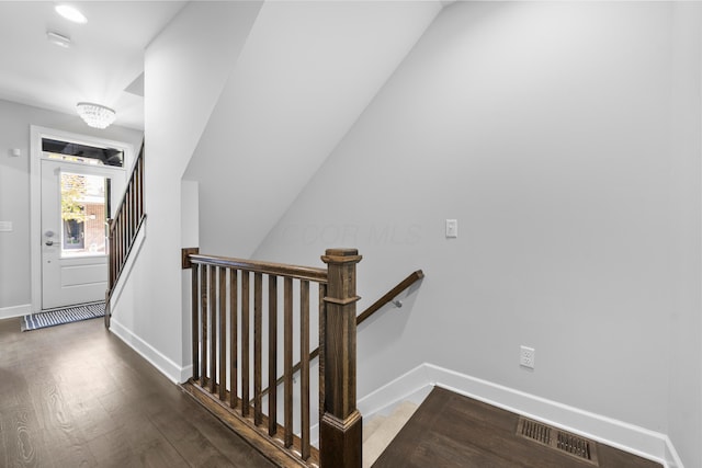 stairs featuring hardwood / wood-style floors and lofted ceiling