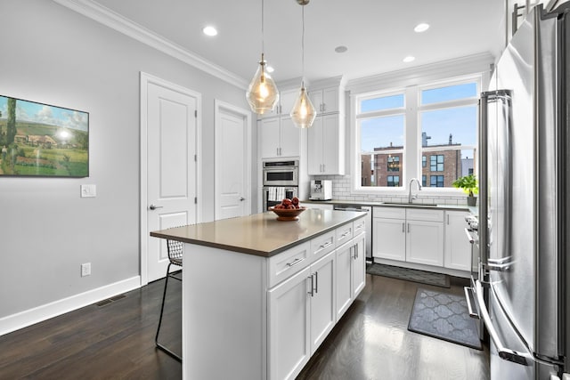 kitchen with white cabinetry, a breakfast bar, a kitchen island, and stainless steel appliances