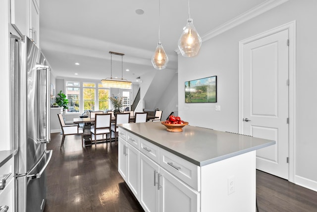 kitchen featuring white cabinets, high end refrigerator, decorative light fixtures, and a kitchen island