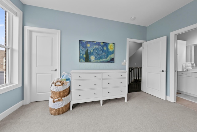 carpeted bedroom featuring ensuite bath