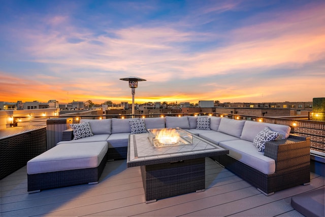 deck at dusk with an outdoor living space with a fire pit