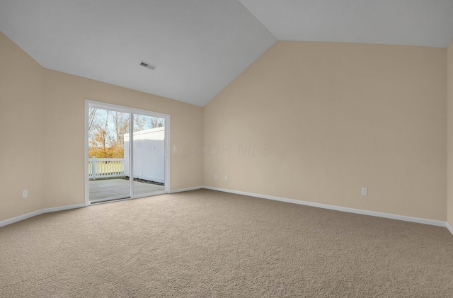 carpeted spare room with vaulted ceiling