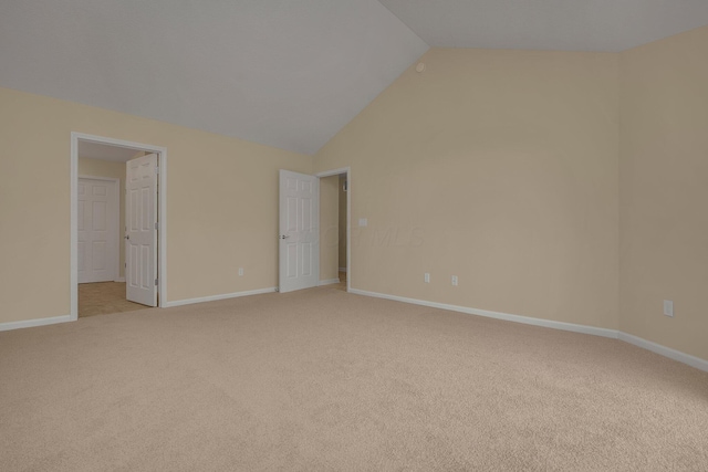 unfurnished bedroom with light colored carpet and vaulted ceiling