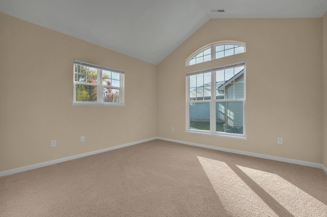 carpeted spare room with a wealth of natural light and vaulted ceiling