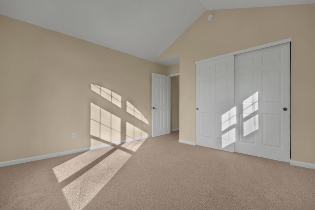 unfurnished bedroom with vaulted ceiling, carpet floors, and a closet