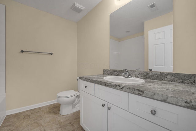 bathroom featuring vanity, a textured ceiling, and toilet