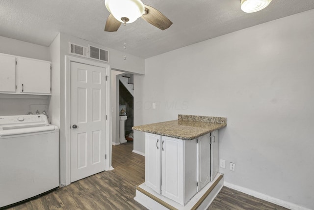 washroom with cabinets, ceiling fan, a textured ceiling, dark hardwood / wood-style flooring, and washer / clothes dryer