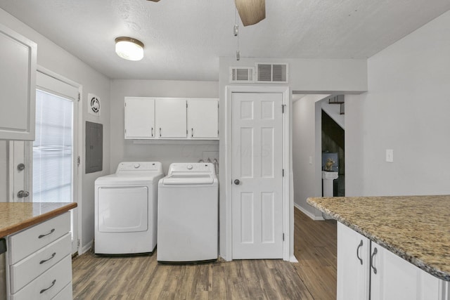 laundry room with cabinets, a textured ceiling, washer and clothes dryer, and dark wood-type flooring