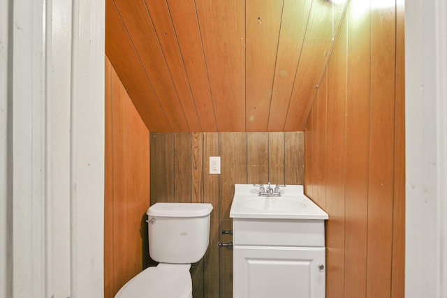 bathroom with vanity, wood walls, wood ceiling, and vaulted ceiling