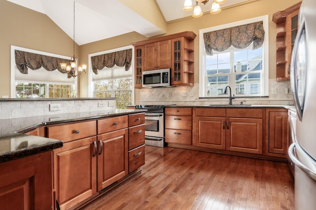 kitchen featuring a chandelier, appliances with stainless steel finishes, lofted ceiling, and sink