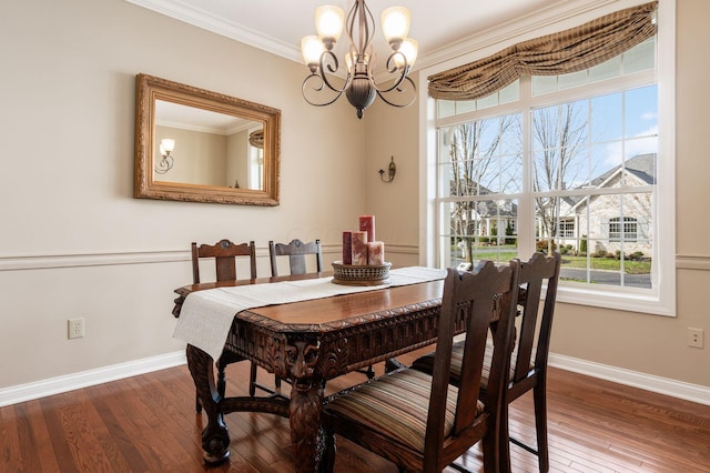 dining room with a chandelier, hardwood / wood-style floors, and crown molding