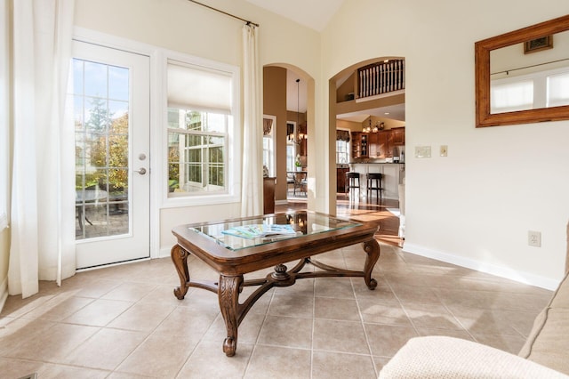 interior space featuring a chandelier, light tile patterned floors, and lofted ceiling