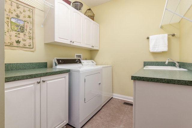 laundry area with washer and dryer, cabinets, light tile patterned floors, and sink