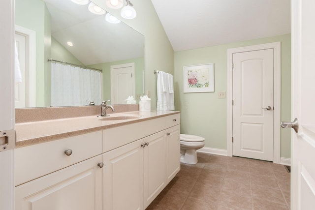 bathroom featuring tile patterned flooring, vanity, toilet, and lofted ceiling