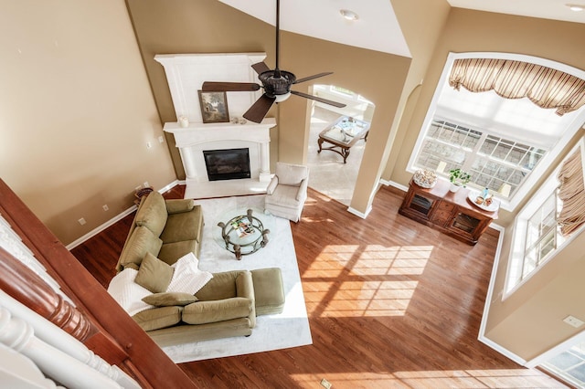 living room featuring ceiling fan, high vaulted ceiling, and light hardwood / wood-style floors