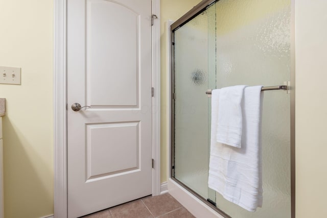 bathroom with tile patterned flooring and a shower with door