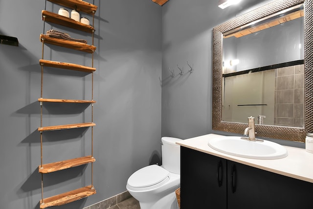 bathroom with tile patterned flooring, vanity, and toilet