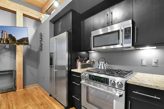 kitchen with beamed ceiling, light wood-type flooring, and premium appliances