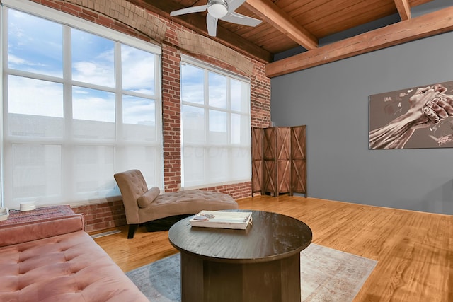 living room featuring beam ceiling, ceiling fan, brick wall, wood ceiling, and hardwood / wood-style flooring