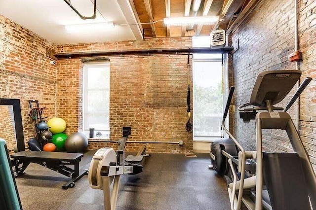 exercise room featuring brick wall