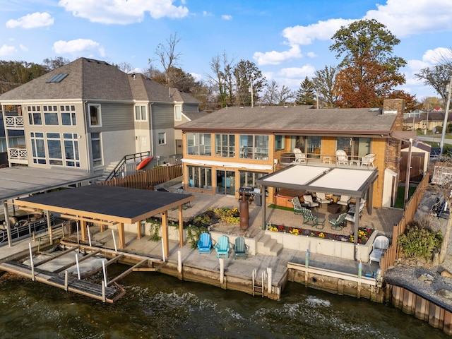 rear view of property featuring a patio area, a water view, and a balcony