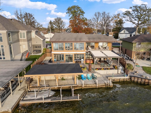 back of house with a water view and a patio