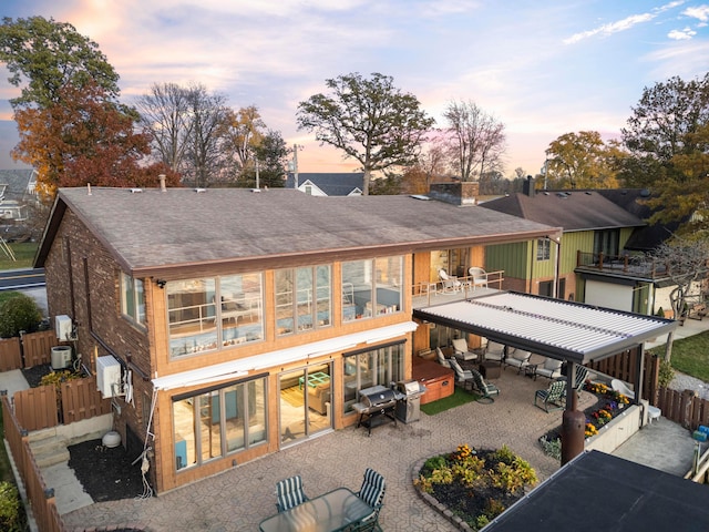 back house at dusk featuring a patio area