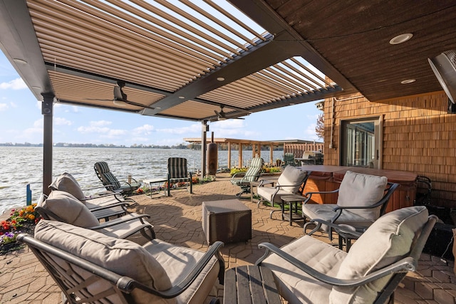 view of patio with a water view, a pergola, and a hot tub