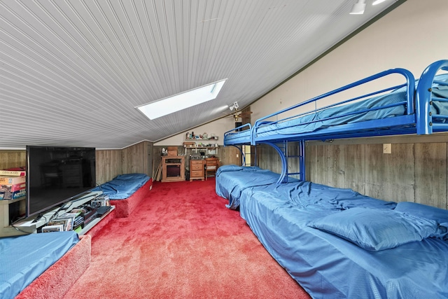 interior space featuring wood walls and lofted ceiling with skylight