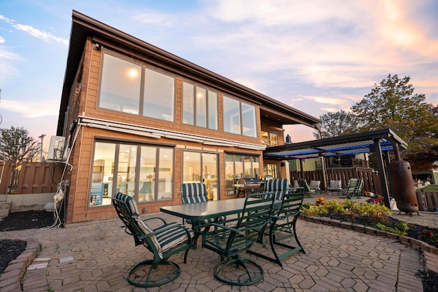 back house at dusk featuring a patio area