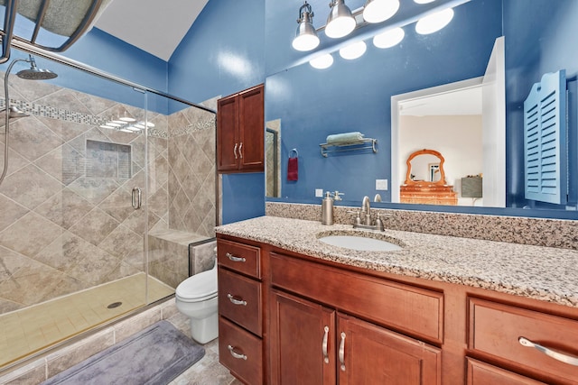 bathroom with vanity, toilet, and a shower with door