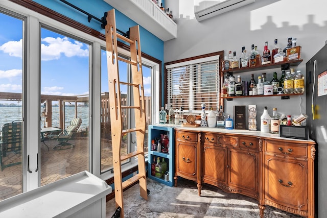 bar featuring a water view, black fridge, and a wall unit AC